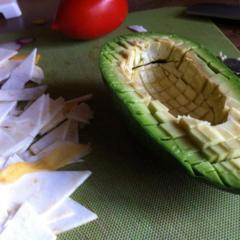 En avocado skiver til små terninger med en sløv kniv, så huden forbliver intakt