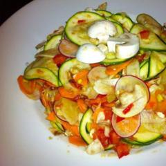 Rå salat lavet af squash, radise, fennikel, gulerødder og champignon med tomat og avocado stykker masseres i det ...